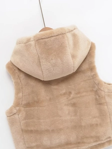 Détail du gilet à capuche en fausse fourrure avec texture matelassée beige clair