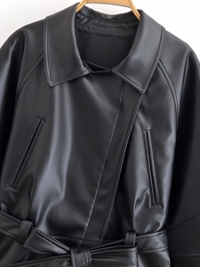Close-up of black PU leather jacket featuring a classic collar and belt knot detail