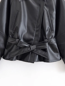 Detail of black PU leather jacket with asymmetrical zipper and tied waist belt bow