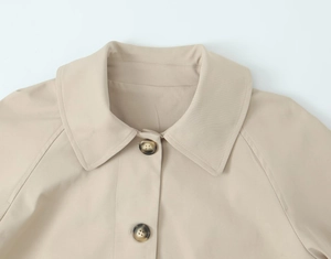 Detailed close-up of khaki trench coat collar with tortoiseshell buttons and premium fabric