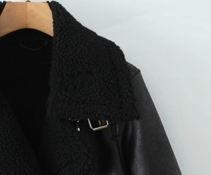 Close-up of black faux leather jacket with thick shearling lining and metal buckle detail