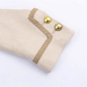 Close-up of beige wool jacket cuff with contrast brown trim and vintage gold buttons