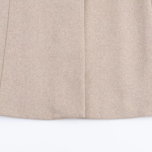 Dettaglio del cappotto di pelliccia sintetica beige con tessuto in lana e cuciture fini
