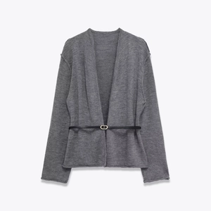 Dettaglio del cardigan in maglia grigia con trama fine e sottile cintura nera con fibbia