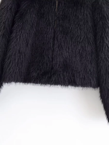 Close-up of black faux fur jacket showing long hair texture and metal zipper detail