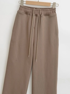 Detail of coffee brown sweatpants with elastic drawstring waist and metal aglets