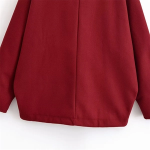 Detail view of the hem and stitching on a deep red wool blend batwing sleeve jacket