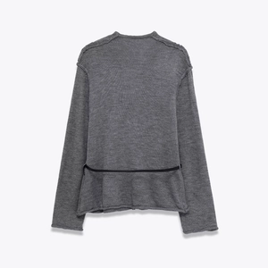 Vista posteriore dettagliata di un top in maglia grigio con cintura decorativa nera