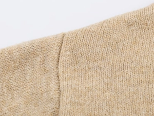 Detailed close-up of oatmeal knit hoodie fabric showing thick knit texture and shoulder seams