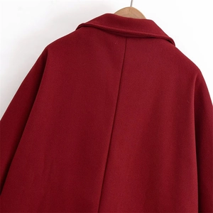 Detail view of the deep red wool coat back with vertical stitching and turn-down collar