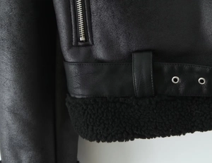 Detail of biker jacket showing silver zipper and belt with metal eyelets and faux fur lining