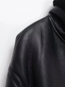 Close-up of black leather jacket featuring premium fleece collar and textured shoulder detail