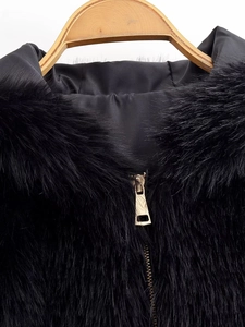 Detail of black faux fur collar with smooth satin lining and golden metal zipper