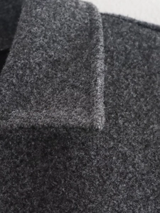 Dettaglio macro del tessuto in misto lana grigio scuro con cuciture professionali