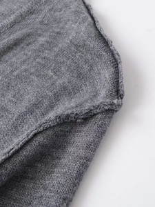 Dettaglio macro della trama in maglia grigia e delle cuciture rifinite di qualità