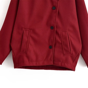 Detail of dark red wool jacket showing black buttons and straight side pockets