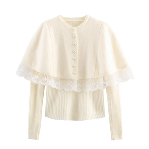 Close-up of cream knit sweater showing white floral lace trim and elegant pearl buttons