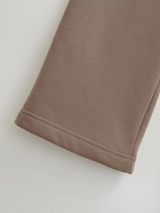 Close-up of brown knit cotton sleeve cuff with professional double needle stitching detail