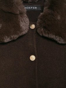 Dettaglio del collo in pelliccia sintetica e bottoni dorati su un cardigan marrone