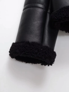 Close-up detail of black leather texture and thick fleece lining on the jacket sleeve