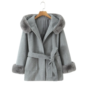 Detail of grey hooded wool coat featuring luxurious faux fur collar and waist tie belt