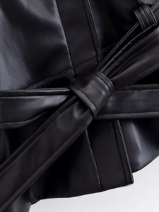 Detailed macro view of the tie-waist belt on a premium black PU leather baseball jacket
