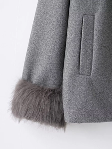 Detail of wool coat featuring plush faux fur cuffs and a hidden side pocket design