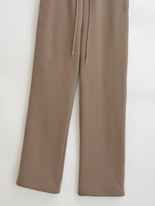 Detail of high-waisted wide leg sweatpants with adjustable drawstring and metal tips