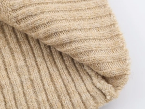 Macro detail of beige ribbed knit texture showing soft premium stitching and wool material