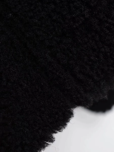 Close-up of thick black faux fur fabric texture showing fluffy warm fleece fibers