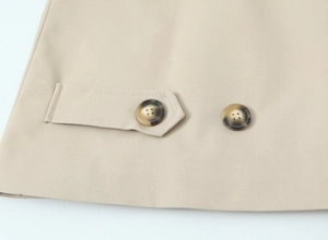Macro detail of twill fabric texture and tortoiseshell buttons on a khaki trench coat