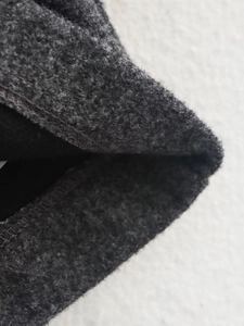 Detailed close-up of dark grey fleece texture and precise stitching on the jacket fabric