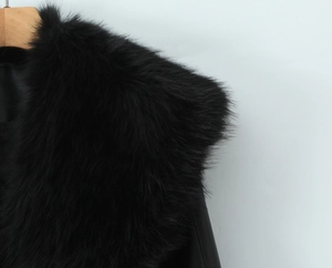 Close-up of thick black faux fur collar on PU jacket showing soft texture and glossy finish