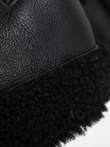 Detailed close-up of premium black pebbled leather and thick fleece lining seam stitching