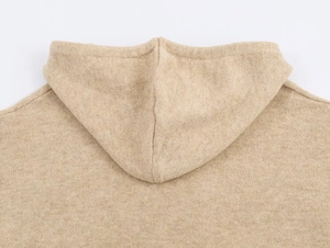 Detailed view of oatmeal knit hoodie fabric texture and back hood seam construction