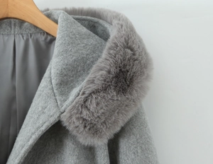 Detail of the soft faux fur collar and wool blend fabric on a grey winter hooded coat