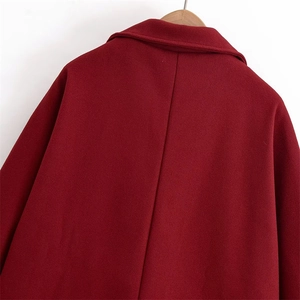 Back view of wine red wool coat with wide lapel and textured fabric on wooden hanger