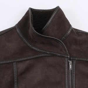 Detailed view of dark brown suede jacket featuring warm shearling lining and leather piping