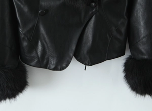 Close-up of black PU jacket featuring faux fur cuffs and textured leather with double buttons