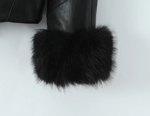 Close-up of black PU leather jacket sleeve featuring thick faux fur cuffs and neat stitching