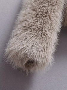 Detailed macro view showing the soft faux fur texture and beige fibers of the coat sleeve