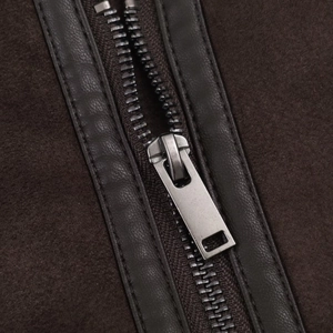 Detail of metal zipper on brown suede jacket with faux leather trim and sturdy stitching