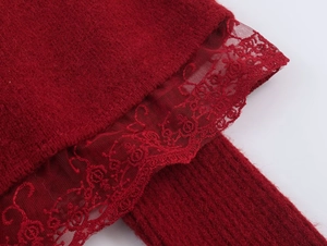 Detail of burgundy knit fabric with elegant lace stitching on the edge of the sweater