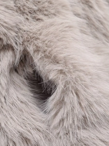 Close-up detail of soft faux fur fabric texture in elegant light greyish brown