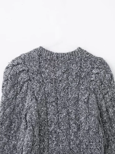 Macro shot of grey cable knit texture and crew neckline on a winter cardigan sweater
