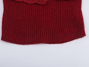 Macro view of dark red ribbed knit fabric with delicate lace trim and wavy edge detail