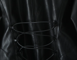 Detailed macro view of the lace-up corset design on the back of a black PU leather jacket
