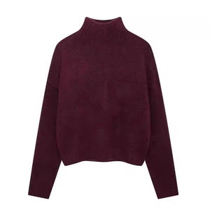 Detail of burgundy turtleneck sweater showing ribbed cuffs and thick knit texture
