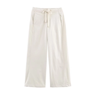Detail view of cream wide-leg trousers featuring elastic drawstring waist and side pockets