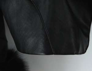 Close-up of black PU leather texture with detailed stitching and soft faux fur trim detail